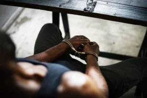 Man handcuffed at a table for interrogation.