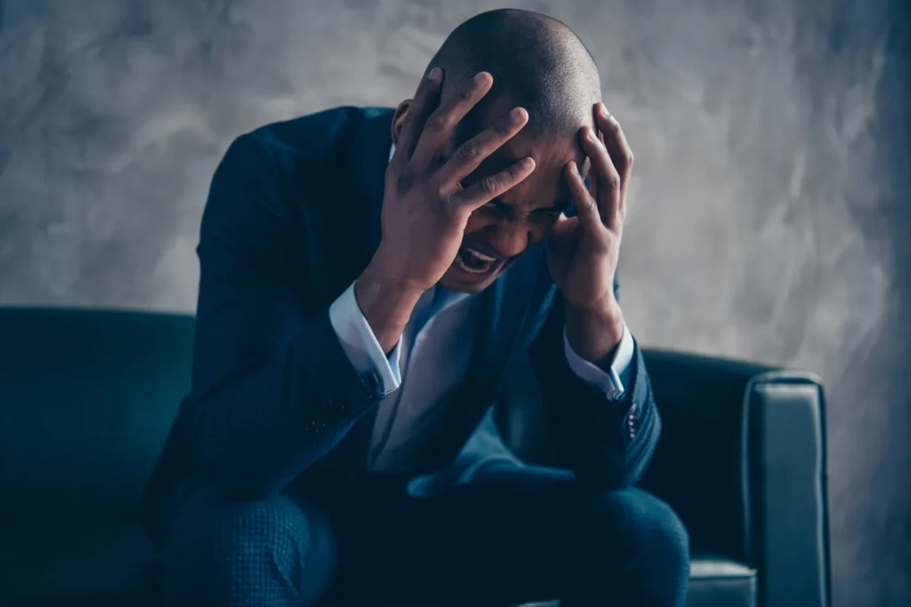 Upset man holding his head.